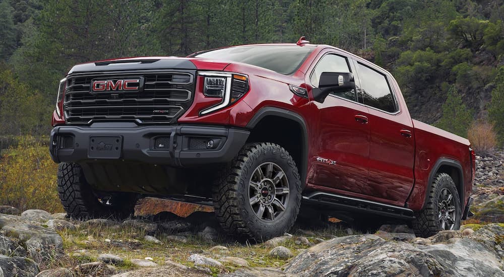 A red 2025 GMC Sierra 1500 parked on rocky terrain.