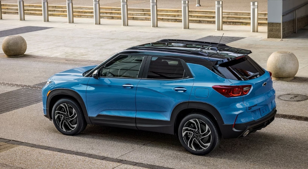 Rear overhead view of a blue 2024 Chevy Trailblazer RS driving to a Chevy dealer near Clinton Township.