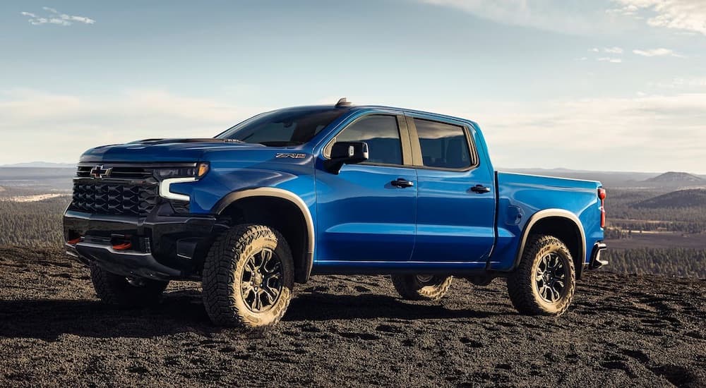 A blue 2024 Chevy Silverado 1500 ZR2 parked off-road and angled left.