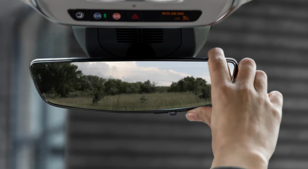 Person adjusting the rear view mirror of a 2025 GMC Terrain.