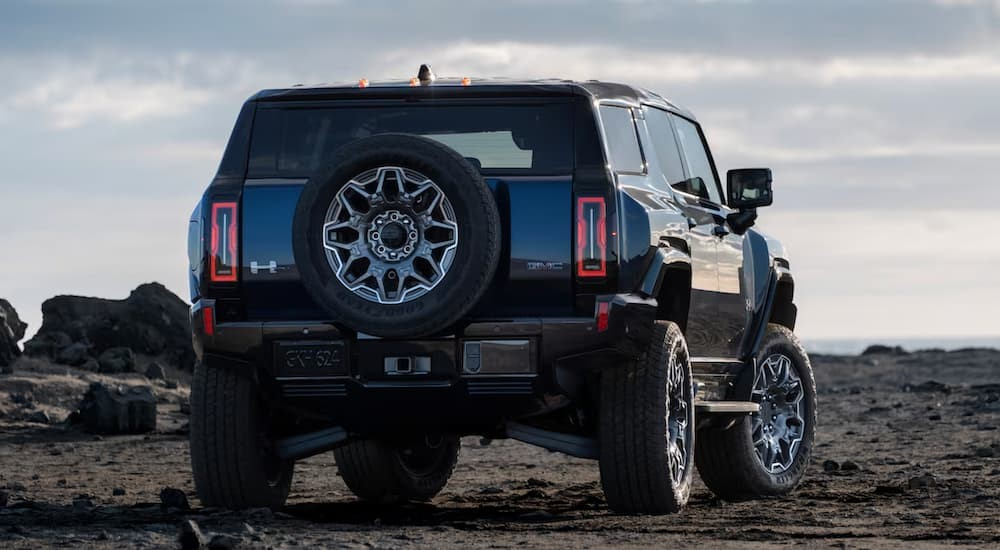 A black 2025 GMC Hummer EV SUV parked off-road.