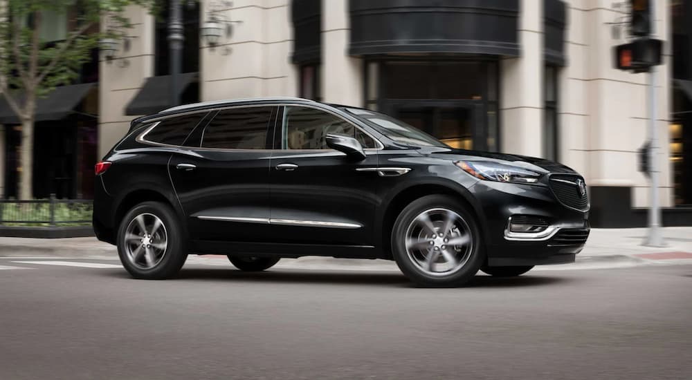 A black 2021 Buick Enclave driving in a city.