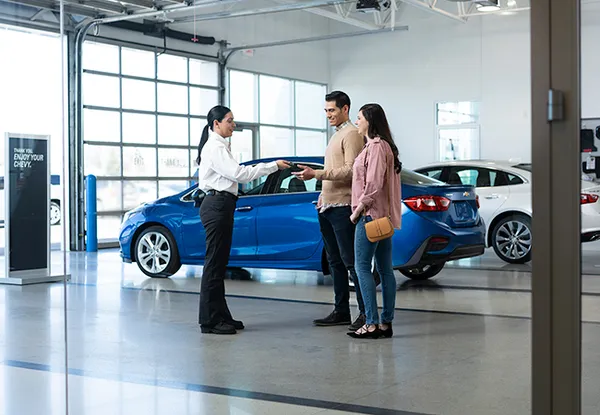 image of a man and a woman shaking hands beside a car
