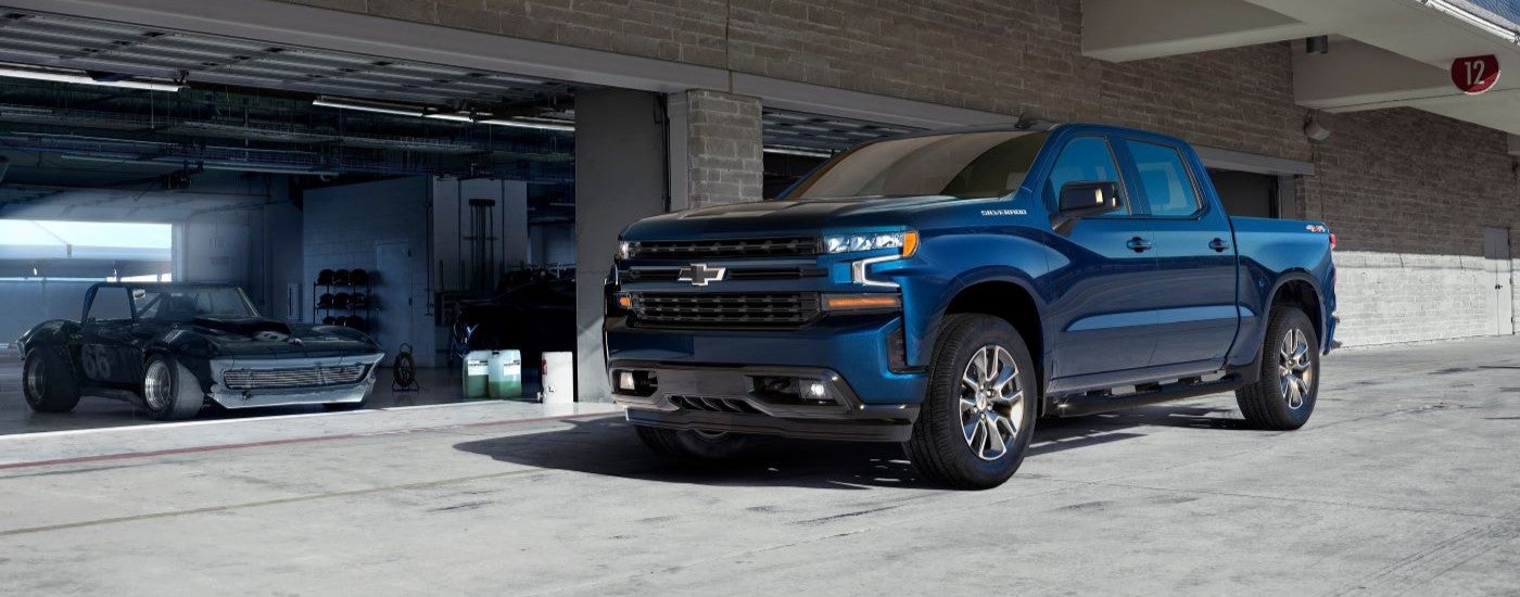 Blue 2019 Chevy Silverado 1500 parked by a garage.