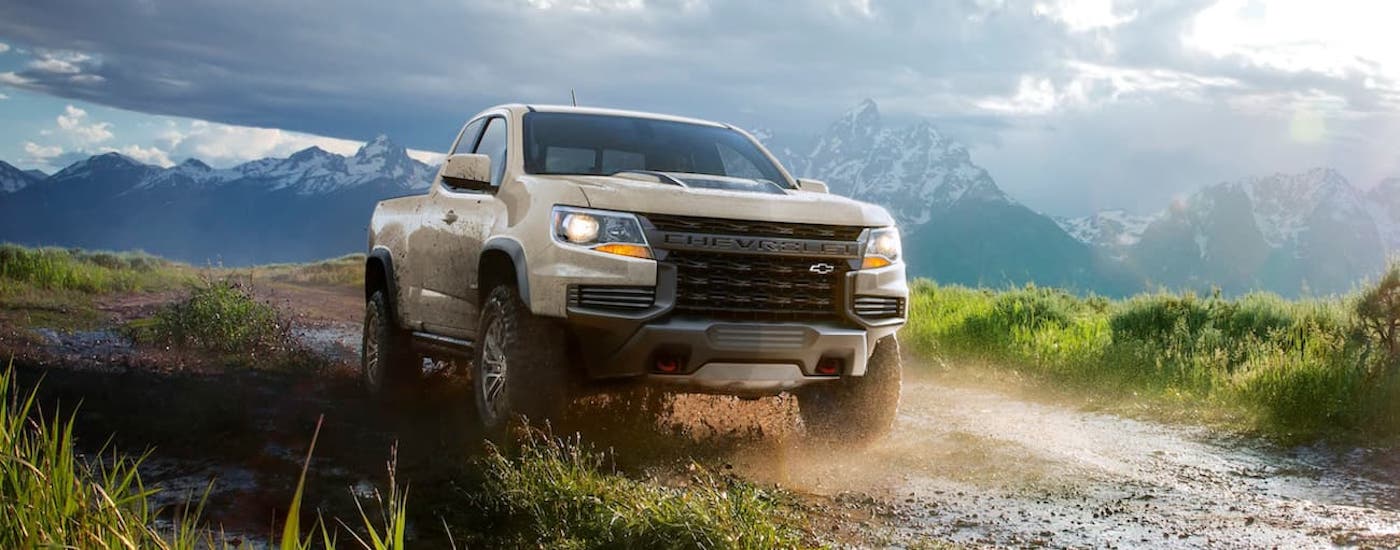 Tan 2021 Chevy Colorado ZR2 driving off-road down a hill.