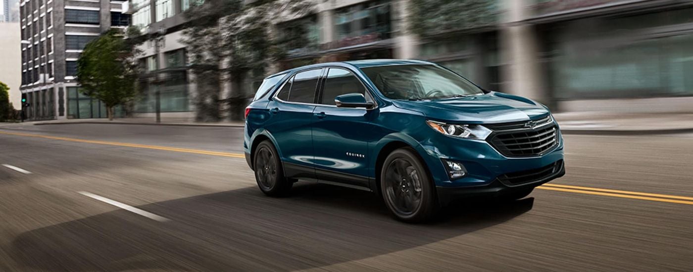 Blue 2021 Chevy Equinox driving down a city street.
