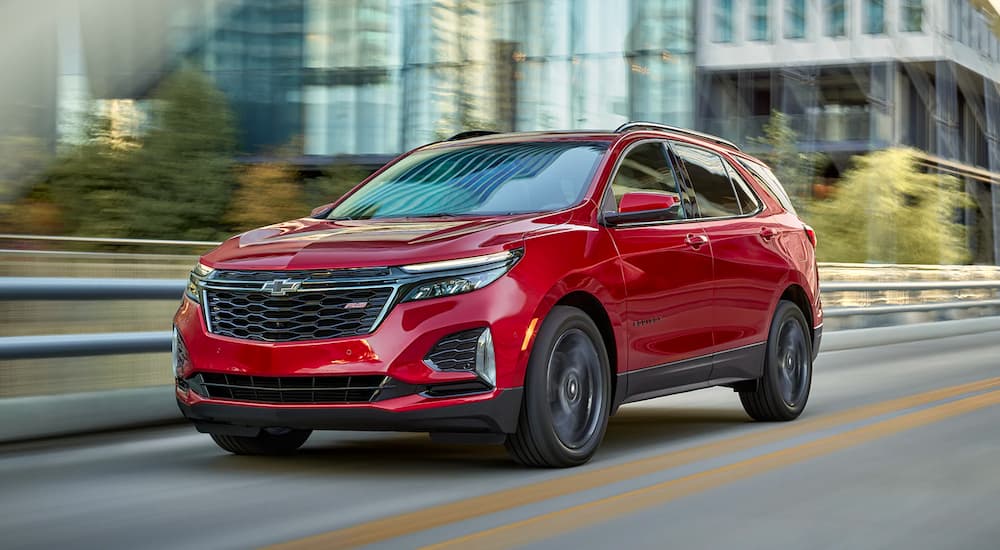 A red 2022 Chevy Equinox RS driving in a city