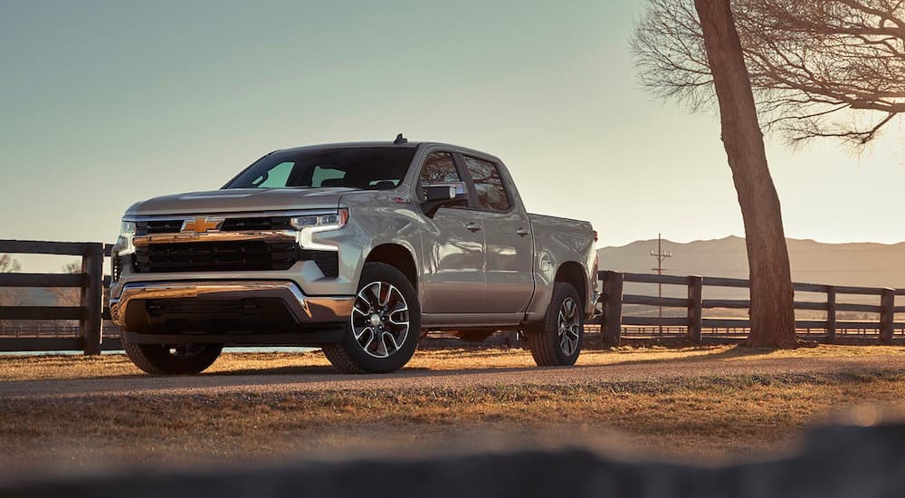Silver 2023 Chevy Silverado 1500 Z71 parked near a ranch fence