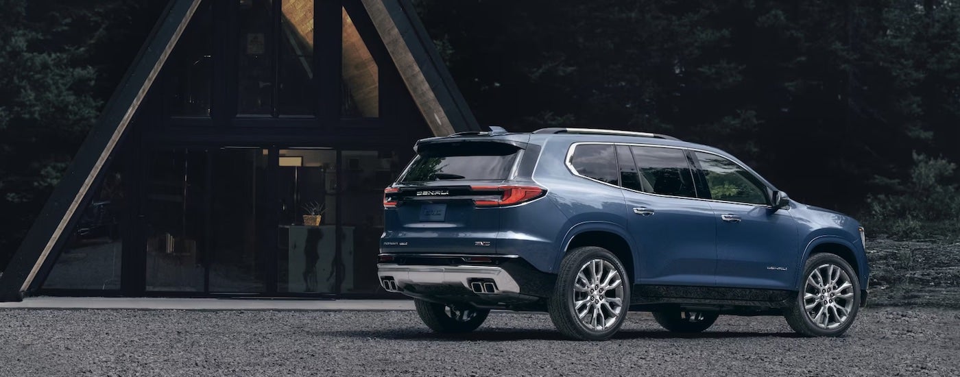 A blue 2024 GMC Acadia Denali is parked near an A-frame.