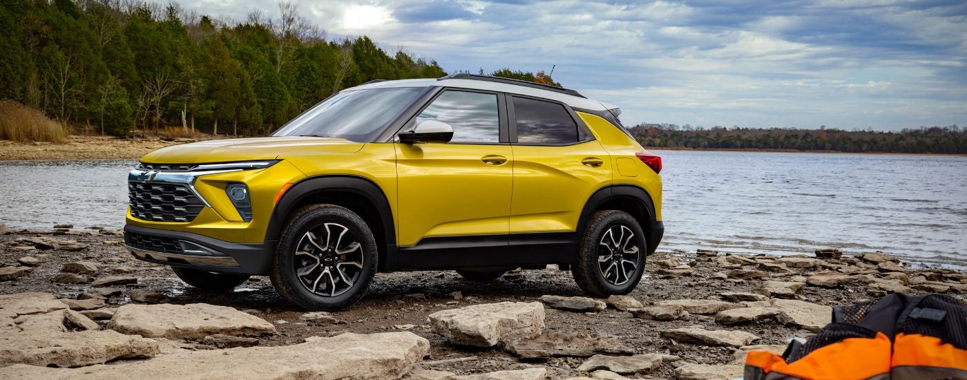Yellow 2026 Chevy Trailblazer parked off-road near a lake.