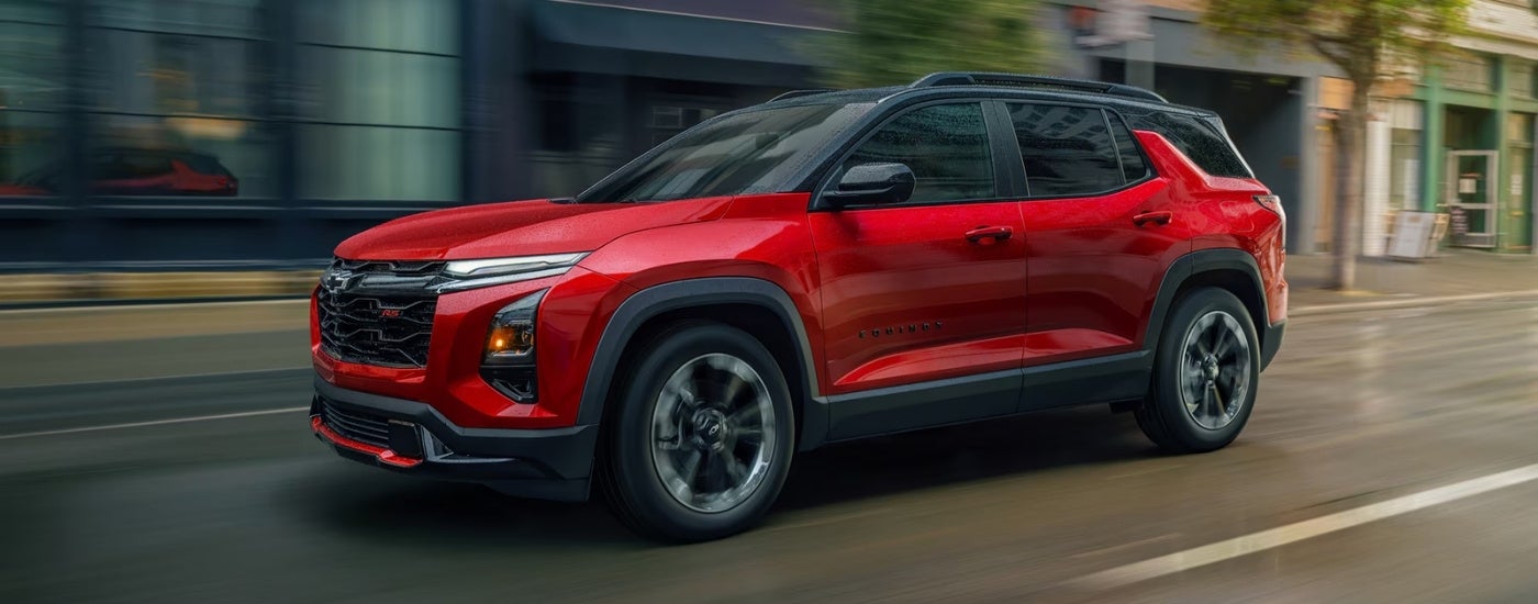 Red 2026 Chevy Equinox RS driving down a road.