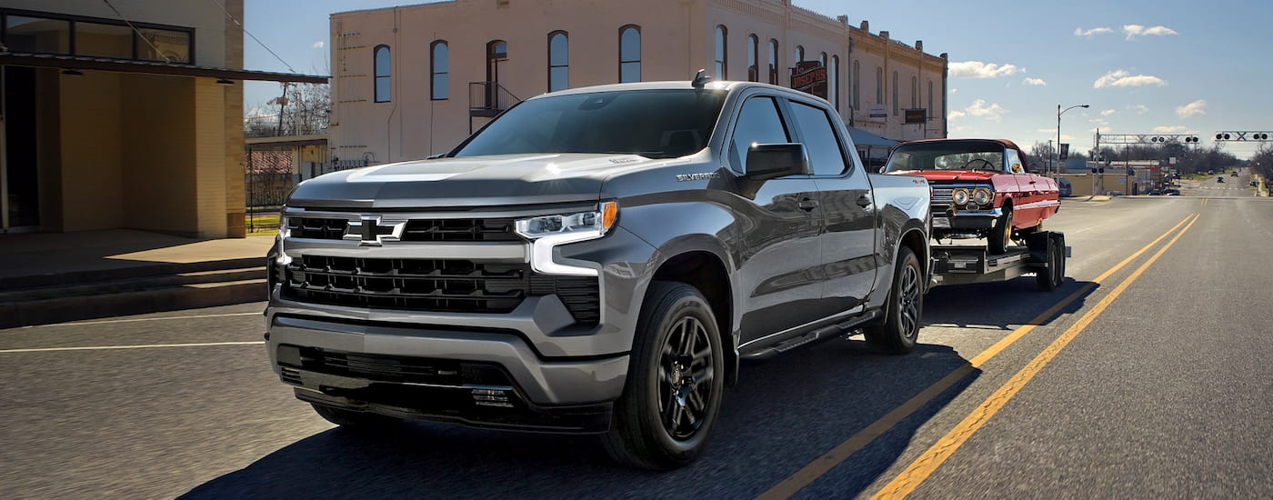Silver 2026 Chevy Silverado 1500 driving down a road.