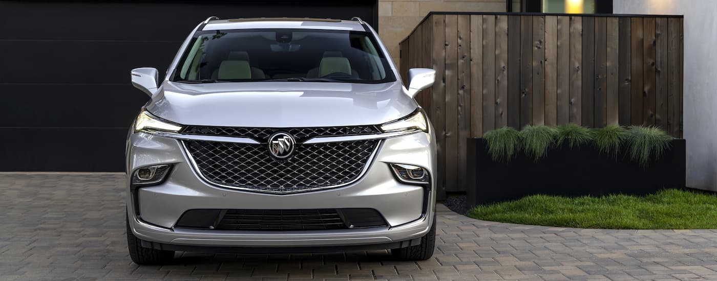 A silver 2022 Buick Enclave Avenir is shown from the front parked in a driveway.