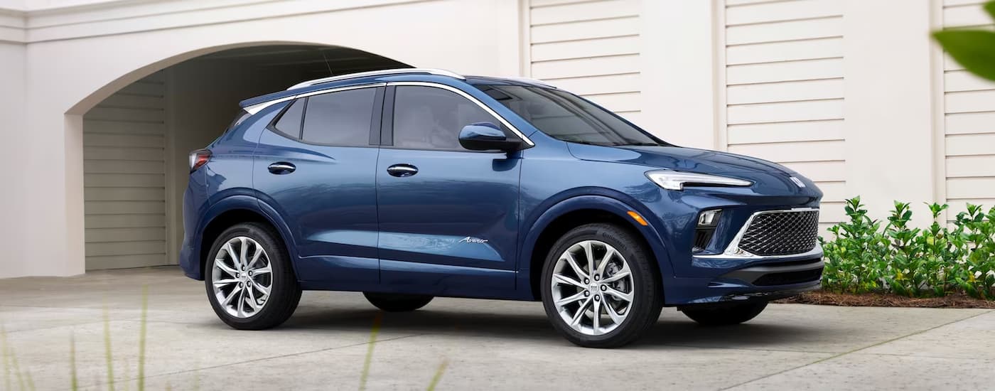 A blue 2024 Buick Encore GX is shown from the side in a driveway.