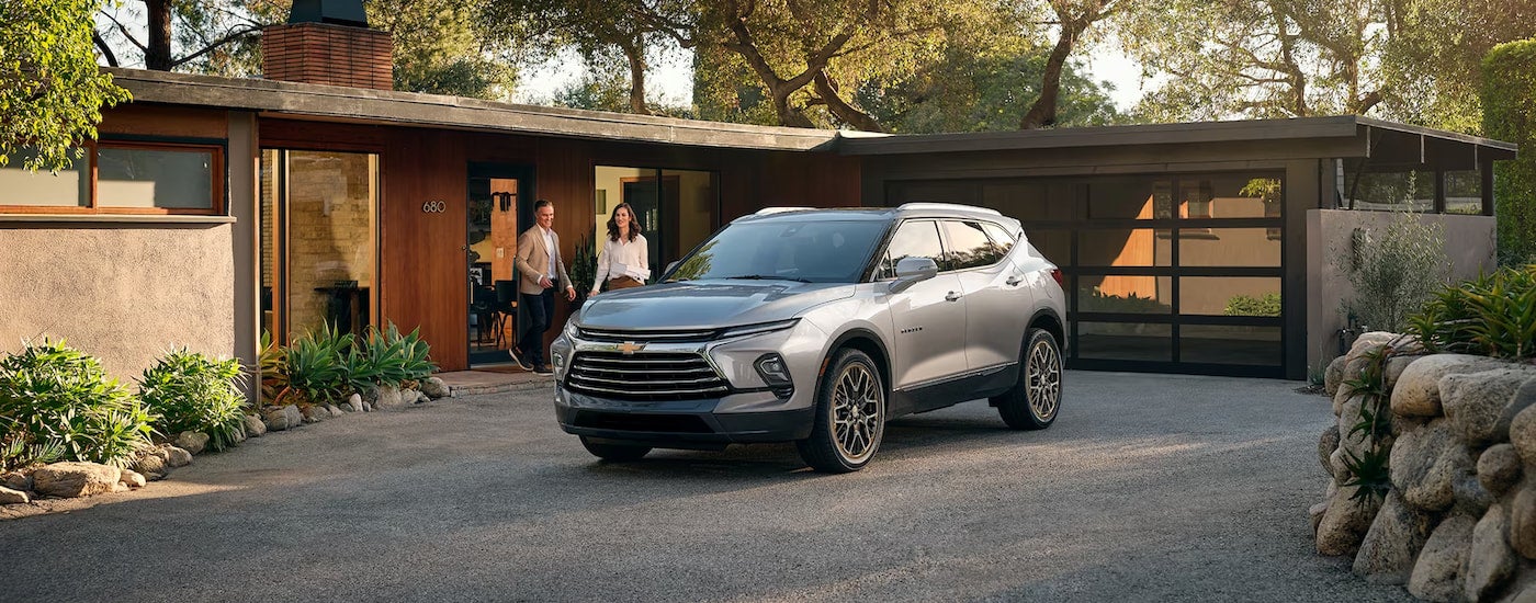 A silver 2024 Chevy Blazer Premier parked on driveway of a modern home.