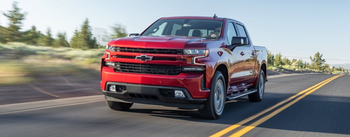 A red 2020 Chevy Silverado 1500 Z71 driving to a used Chevy dealer.