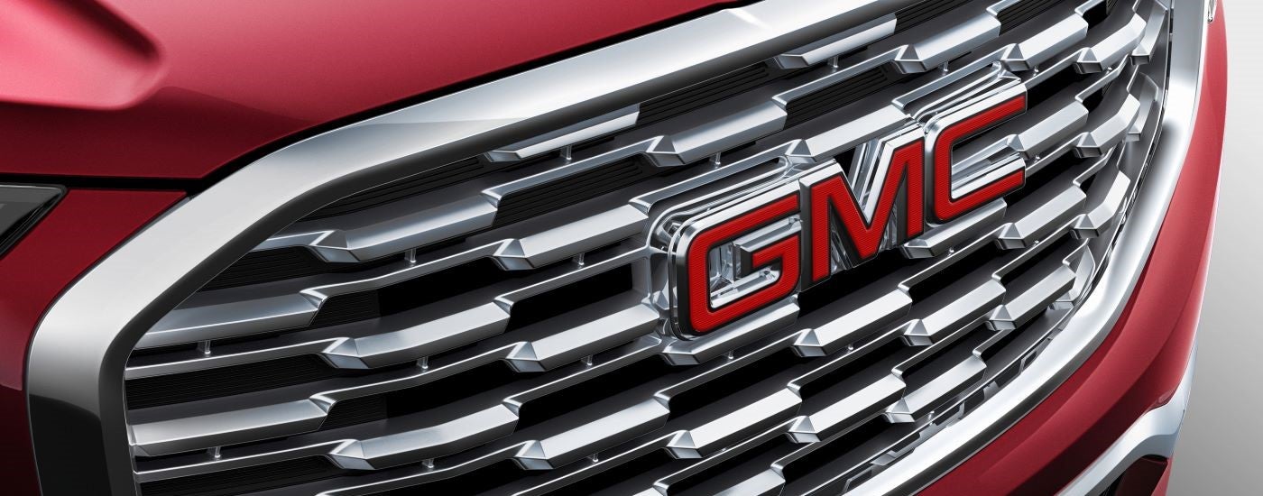 The grille and badge of a red 2018 GMC Terrain Denali.